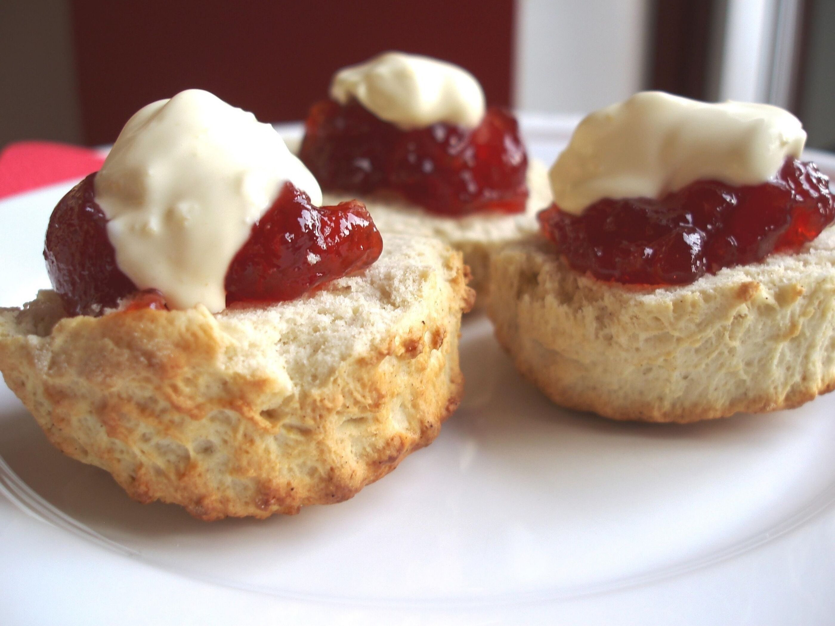 A photograph of scones with jam and cream